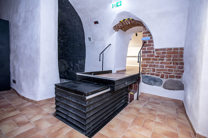 Platforma uniesiona na wysokość wyższego poziomu, tworzy gładką powierzchnię do przejścia ponad schodami. Te zupełnie przykryte mechanizmem podnośnika.