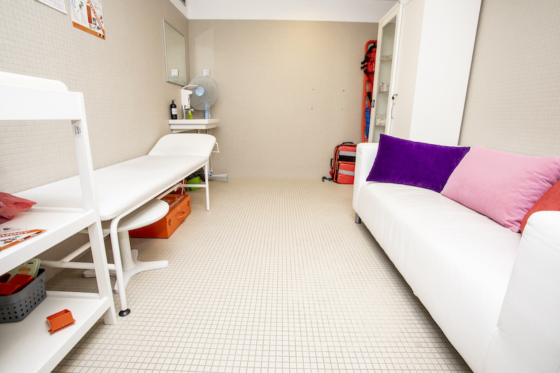 Pokój wyciszenia. Niewielkie pomieszczenie, na podłodze jasne kafelki, ściany w kolorze beżowym. Po prawe stronie biała kanapa, po lewej leżanka. W rogu biały regał.